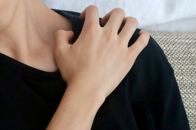 肩を搔く男性の写真